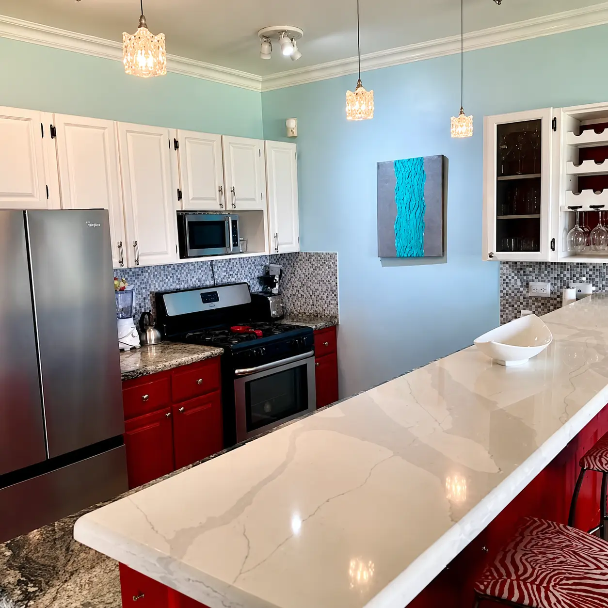 Kitchen breakfast bar with pendant lights, wine rack, marble countertop, and ocean-inspired artwork on blue walls
