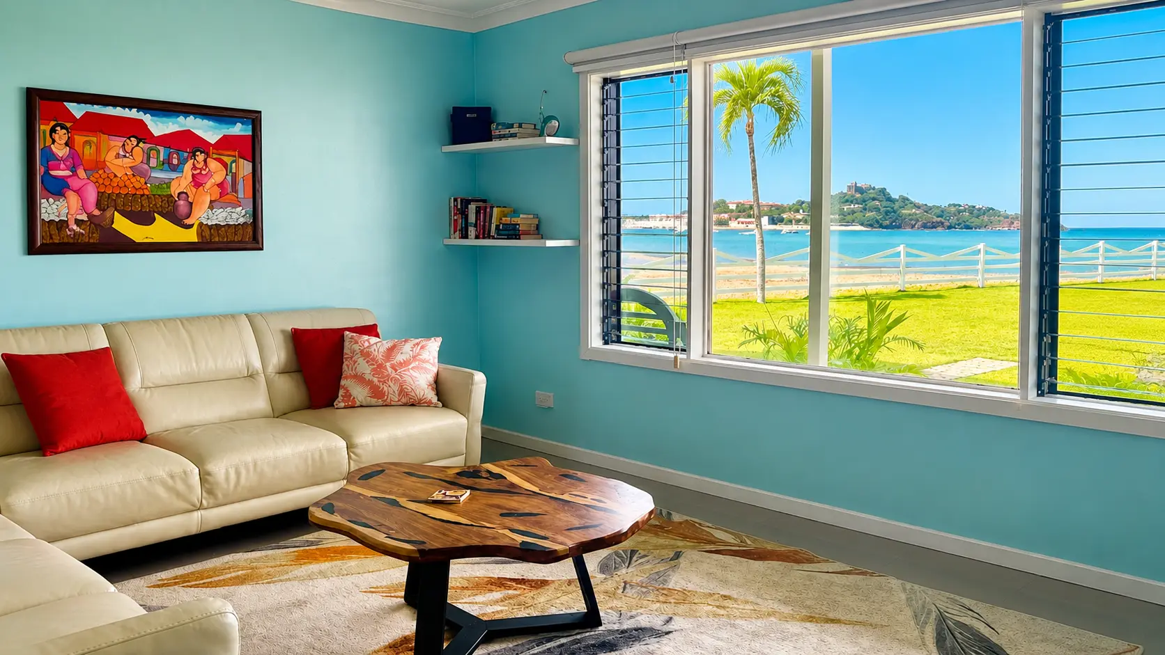 Living room with leather sofas, handcrafted wood coffee table, and large window framing Potrero Bay, palm trees, and Flamingo Marina across the water