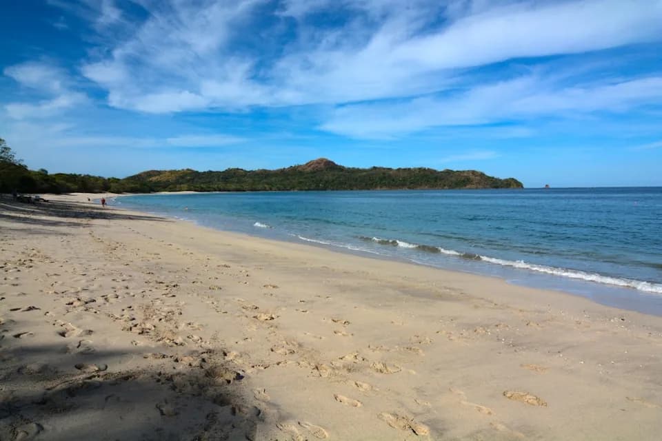 Playa Brasilito beach with calm water and fishing boats along the shore